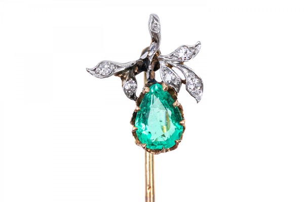An impressive 14K yellow gold stick pin set with a single pear cut exceptional emerald and accented with round cut diamonds. The emerald is approximately 0.5 cts and the diamonds are approximately 0.1 TCW. 